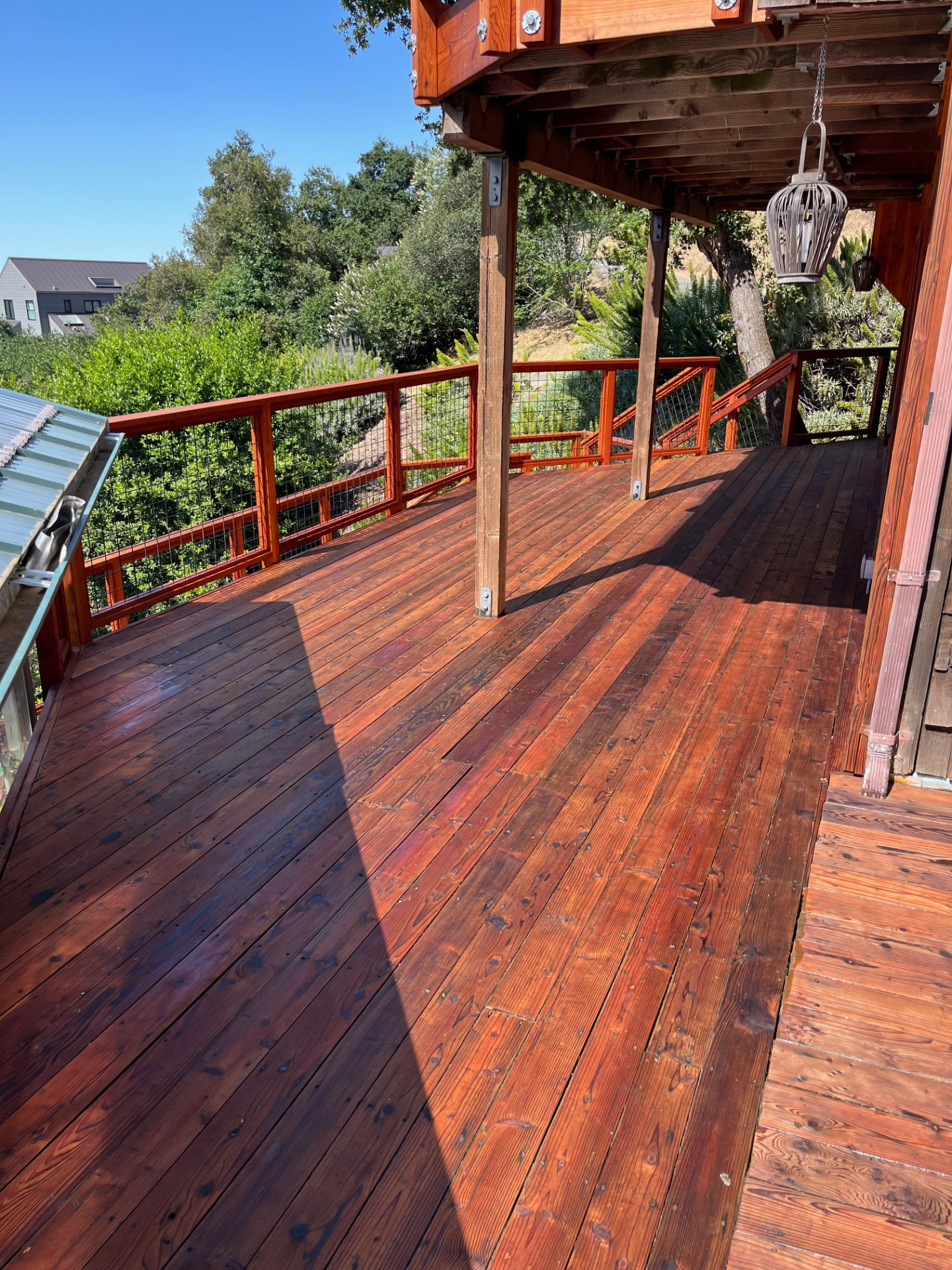 Wide redwood deck refinished with rich stain