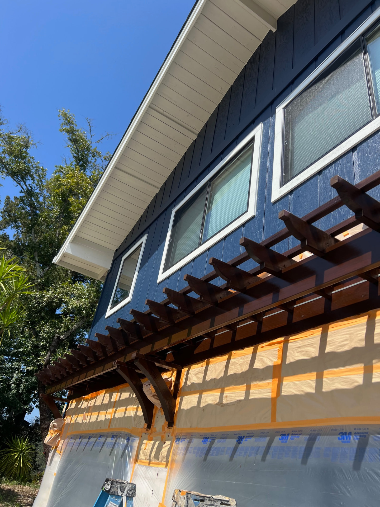 Masked and prepped exterior with newly stained pergola