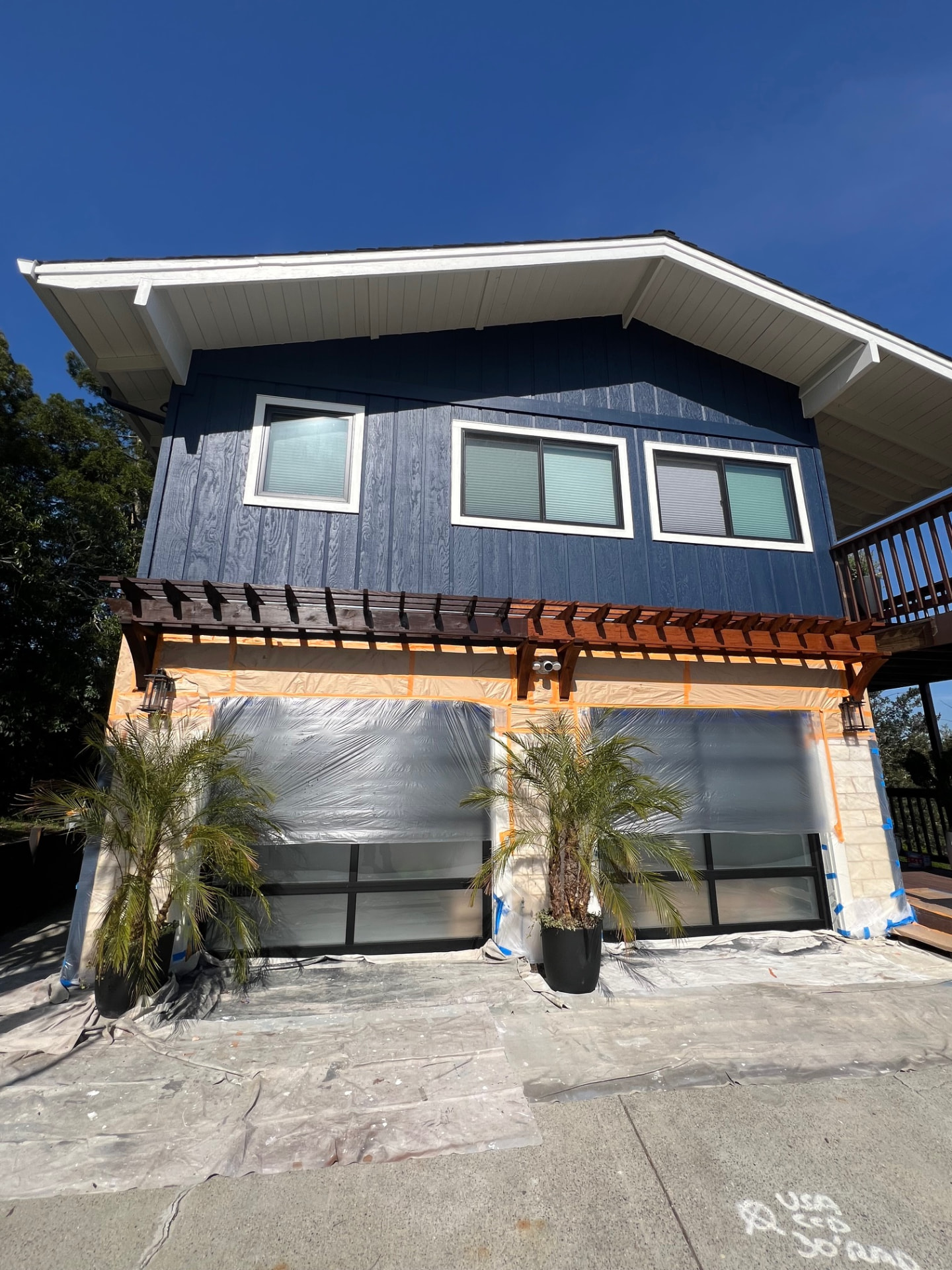 Two-story home with fresh navy board-and-batten siding and white trim
